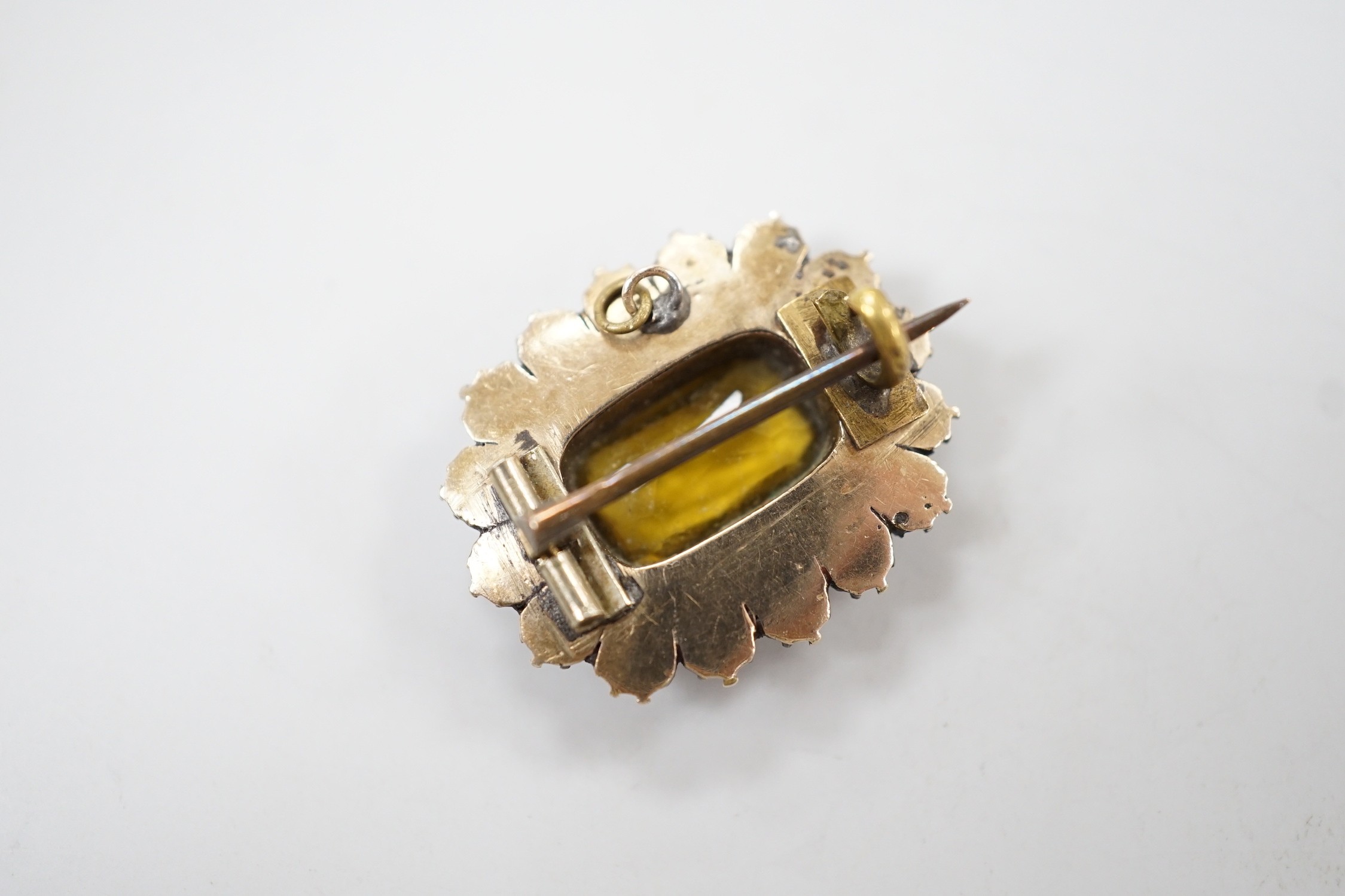 An early 19th century yellow metal, yellow paste, foil backed garnet and split pearl set oval brooch, 24mm.